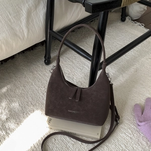 Detail of dark brown matte hobo bag featuring semi-circle shape and Fashion & Bags embossing