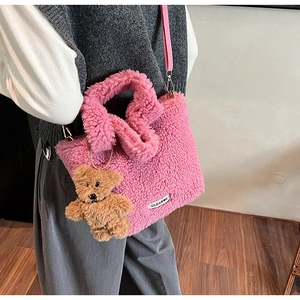 Pink faux shearling bucket bag with cute brown bear charm and adjustable shoulder strap