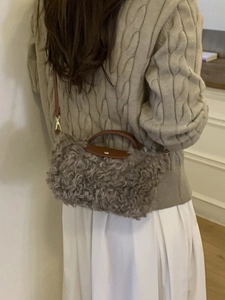 Gray faux fur crossbody bag with brown leather trim shown on a model in autumn outfit