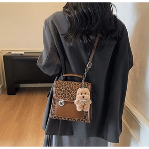 Gros plan détaillé du sac à main léopard avec charmant pendentif d'ours en peluche