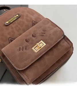 Detail of a brown leopard print backpack with cat embroidery and a gold buckle lock
