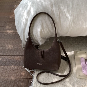Detailed texture of brown retro leather dumpling bag with adjustable shoulder strap