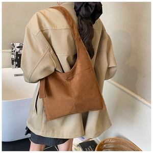 Detail of caramel brown suede tote bag featuring a wide integrated shoulder strap for daily use