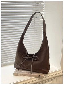 Detail of dark brown suede and leather hobo bag with an elegant bow accent