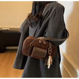 Detail view of vintage brown suede baguette bag with colorful beads and zipper details