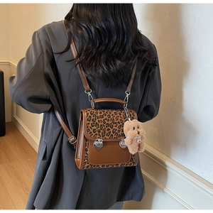 Sac à dos en cuir marron avec détails léopard et breloque ours en peluche sur un modèle