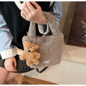 Detail of grey teddy plush bucket bag with cute brown bear charm and Clear-K label