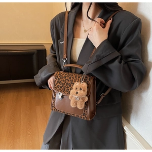 Détail du sac bandoulière léopard marron avec fermoir vintage et breloque ourson