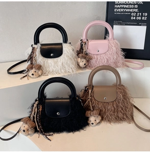 Detalle de bolsos bandolera de pelo sintético en cuatro colores con colgantes de ositos