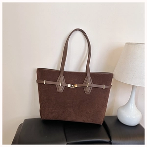 Detail of dark brown tote bag featuring golden metal buckle and retro suede texture