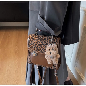 Détail du sac bandoulière léopard avec rabat en simili cuir marron et breloque peluche