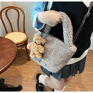 Detailed texture of grey faux shearling bucket bag with a cute teddy bear charm