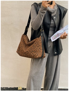 Chic leopard print hobo bag with black leather shoulder strap and gold buckle detail