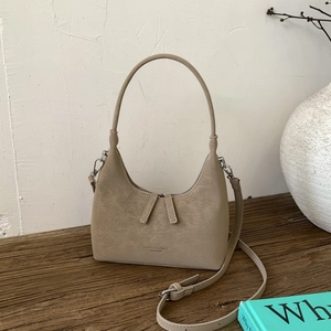 Detail view of khaki dumpling bag with vintage leather texture and adjustable strap
