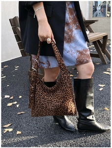 Detail of leopard print shoulder bag with metallic eyelets and adjustable buckle strap