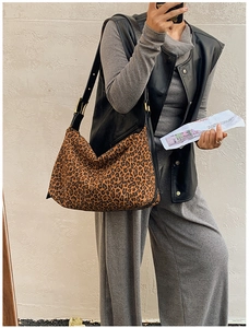 Detail of leopard print hobo bag showing suede texture and black leather shoulder strap