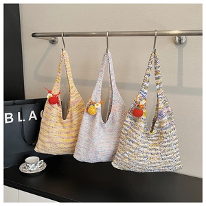 Detail of colorful crochet tote bags featuring handmade fruit charms in a lifestyle setting