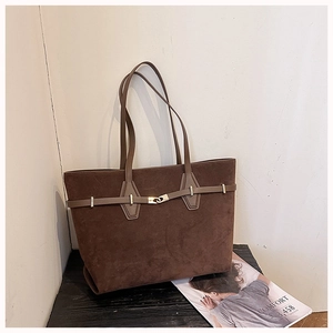 Detail view of large dark brown suede tote bag with metal buckle and shoulder strap