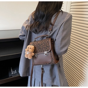 Vue détaillée du sac bandoulière rétro à motif léopard avec pendentif ours sur modèle