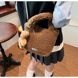 Brown fuzzy teddy bucket bag with cute bear charm and woven label detail
