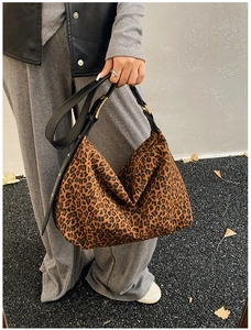 Detail of leopard print hobo tote bag with adjustable leather strap in outdoor setting