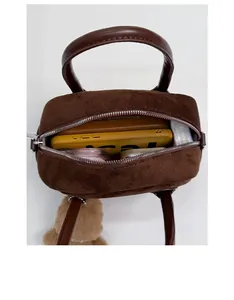 Draufsicht der braunen Wildledertasche mit geräumigem Innenraum und Bärenanhänger
