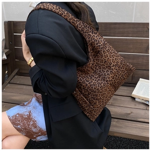 Detail of leopard print canvas tote bag featuring wide shoulder straps and spacious design