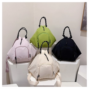 Detailed display of four colorful waterproof mini backpacks with woven rope handles on stands