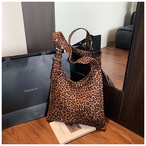 Detailed close-up of leopard print shoulder bag featuring metal adjustable strap buckle