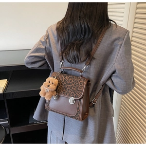 Détail du sac à dos vintage à motif léopard avec fermoir en métal et breloque ourson