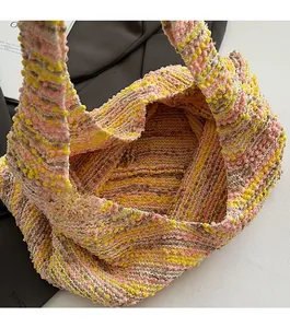 Macro view of woven tote bag showing pink and yellow knit texture and open design