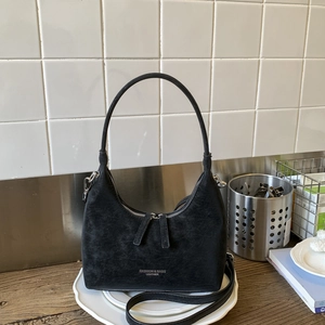 Detail view of the retro textured black crescent bag with fine grain leather finish