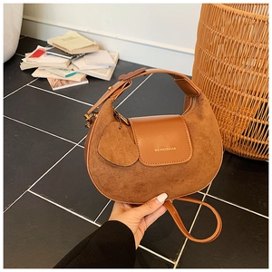 Detail of vintage brown suede hobo bag with adjustable strap and leather flap closure