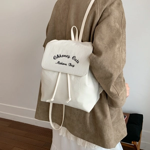 White nylon drawstring backpack featuring black letter embroidery and slim shoulder straps