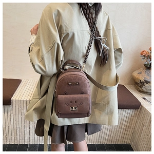 Detail of a brown mini backpack with cute cat ears and a metallic chain strap