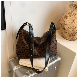 Detail of leopard print canvas tote bag with black adjustable strap and gold hardware