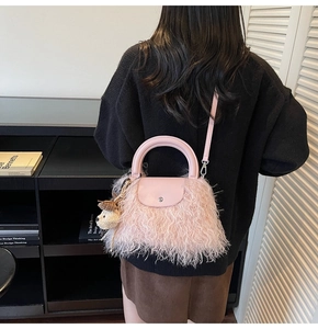 Bolso rosa de felpa con colgante de oso y asa de cuero sintético en un entorno de estilo de vida