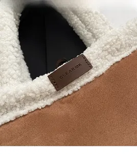 Close-up of fluffy white faux fur and brown suede texture with Clear K brand tag