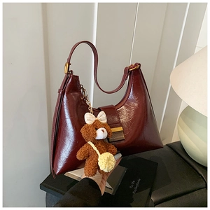 Burgundy hobo bag with glossy pleated texture, gold hardware and brown teddy bear charm