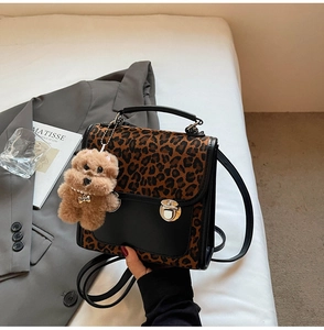 Détail du sac à main léopard avec fermoir argenté et breloque chien en peluche sur tissu