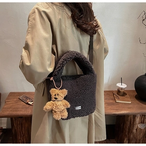 Deep grey fluffy faux fur bucket bag with a cute bear charm shown in a lifestyle setting