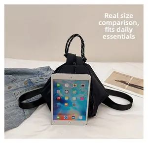 Waterproof black triangular backpack size comparison with a tablet and everyday items
