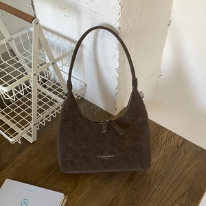 Detail view of the vintage dark brown dumpling bag featuring textured suede leather