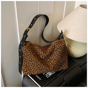 Detail of leopard print hobo bag canvas texture with adjustable black leather shoulder strap