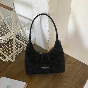 Detail showing vintage black suede texture and printed logo on the crescent bag