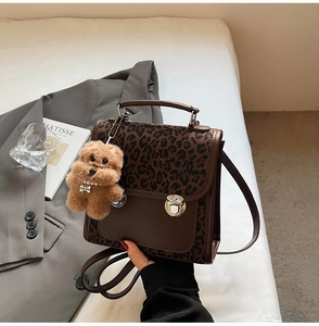 Détail du sac à main léopard avec un pendentif ours en peluche et un fermoir métallique