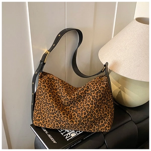 Detail of adjustable black leather strap and gold buckle on leopard print hobo bag