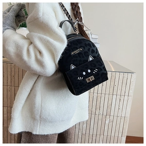 Detail of a black leopard print backpack featuring cute cat ears and embroidered cat face