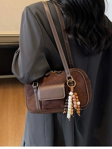 Deep brown vintage frosted shoulder bag with tassel charm shown from a 45-degree back view