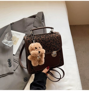 Détail du sac à dos léopard avec garniture en cuir et breloque chiot mignonne